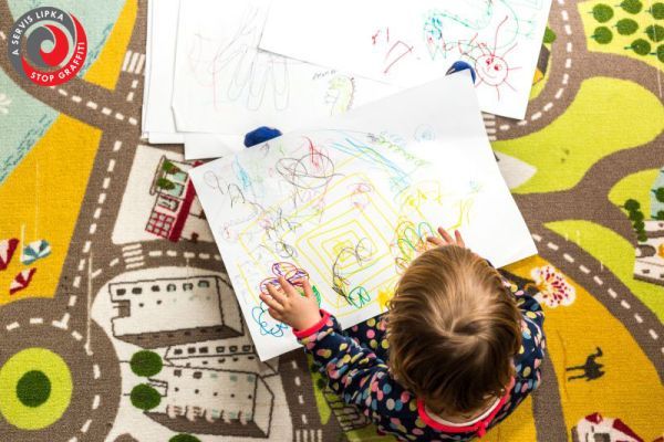 bambina gioca con disegni su tappeto colorato